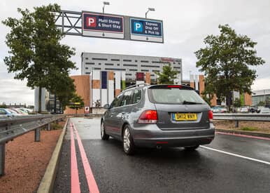 car driving beneath car park signs at liverpool airport