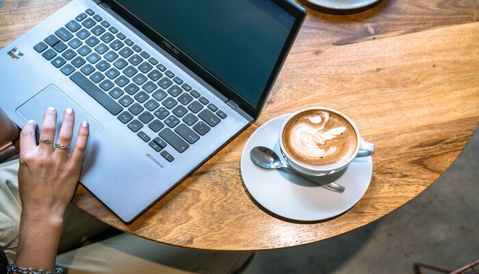Café y ordenador portátil sobre una mesa en una sala VIP