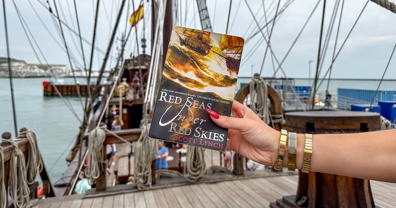 Person reading a book in a location directly tied to the story.