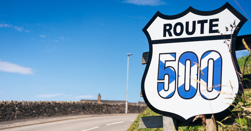 Scenic cycling route with mountains and lake in the background